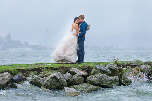 The newlyweds taking photos at Lake Rotorua, New Zealand, on a rainy day.