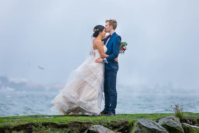 The newlyweds taking photos at Lake Rotorua, New Zealand, on a rainy day.