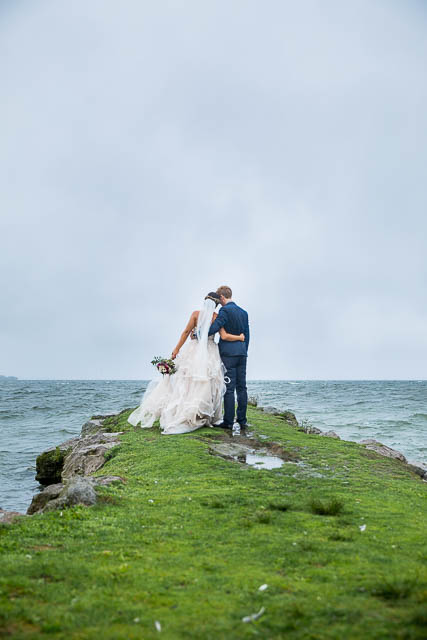 Bride and groom kissing on the Rotorua Lake lake front in New Zealand.