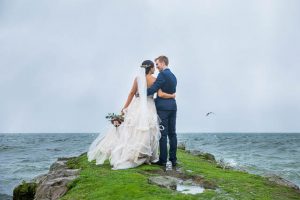 Bride and groom kissing on the Rotorua Lake lake front in New Zealand.