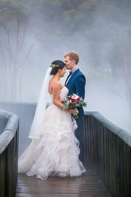 Bride and groom walking around the geothermal Kuirau Park in Rotorua, New Zealand.
