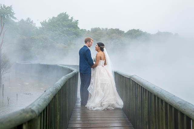 Bride and groom walking around the geothermal Kuirau Park in Rotorua, New Zealand.