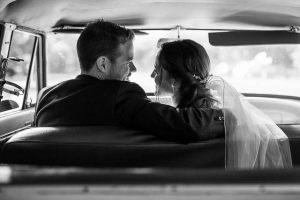 Bride and groom kissing in vintage car on the Ojai wedding day.
