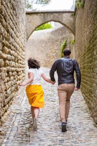 Wedding photographs of couple walking together in the Cité de Carcassonne, a medieval fortress.