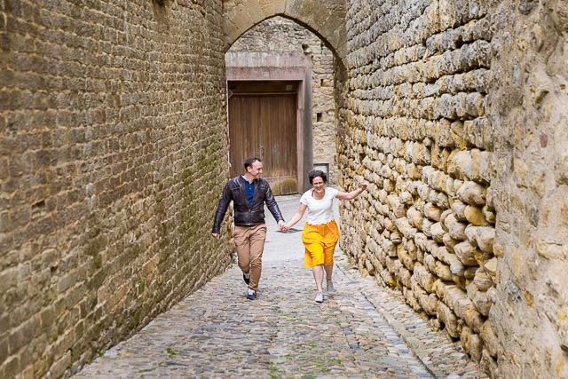Wedding photographs of couple walking together in the Cité de Carcassonne, a medieval fortress.