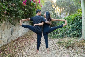 The engaged couple doing yoga poses during their yogi engagement photoshoot.