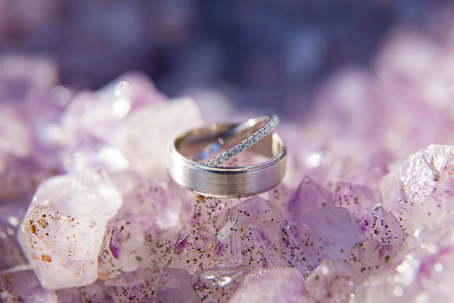 Wedding rings placed on amethyst rock formation.