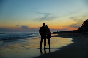 Beach sunset silhouette photos of a couple taken during their Santa Barbara beach engagement photoshoot.