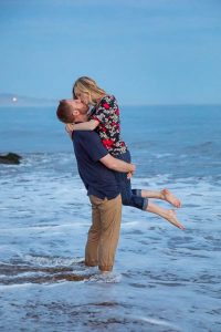 Couple having fun, being playful at their Santa Barbara beach engagement photoshoot.