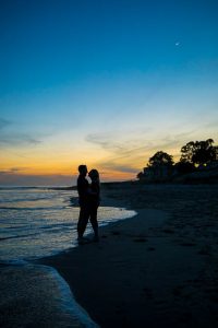 Beach sunset silhouette photos of a couple taken during their Santa Barbara beach engagement photoshoot.