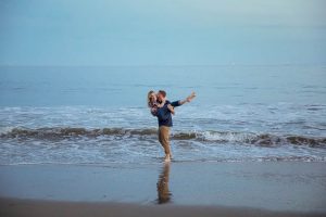 Couple having fun, being playful at their Santa Barbara engagement photoshoot.