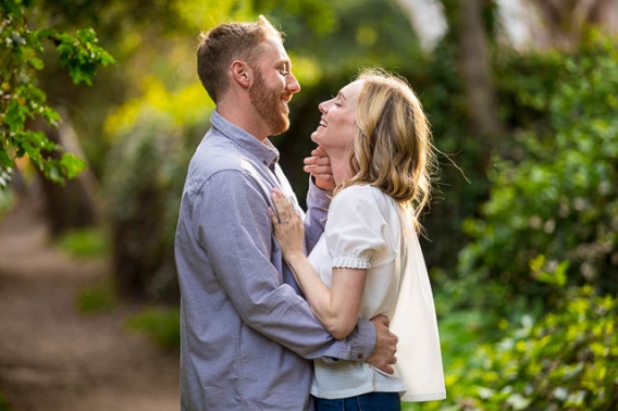 Couple embracing by the flowers during their Santa Barbara engagement photoshoot.