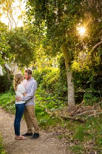 Couple embracing by the flowers during their Santa Barbara engagement photoshoot.