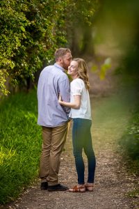 Couple embracing by the flowers during their Santa Barbara engagement photoshoot.
