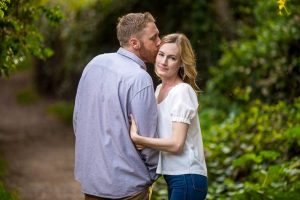 Couple embracing by the flowers during their Santa Barbara engagement photoshoot.