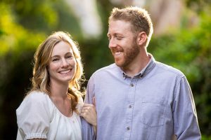 Couple embracing by the flowers during their Santa Barbara engagement photoshoot.