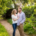 Couple embracing by the flowers during their Santa Barbara engagement photoshoot.