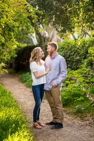 Couple embracing by the flowers during their Santa Barbara engagement photoshoot.