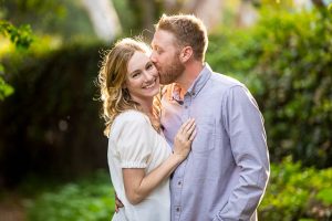 Couple embracing by the flowers during their Santa Barbara engagement photoshoot.