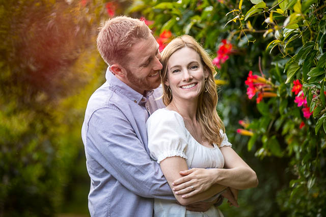 Couple embracing by the flowers during their Santa Barbara engagement photoshoot.