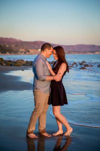 Engaged couple embracing during their sunset Santa Barbara engagement photoshoot.