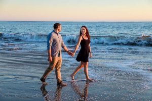 Fiancé and Fiancée strolling together during their romantic Santa Barbara beach engagement photoshoot.