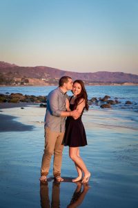 Engaged couple embracing during their sunset Santa Barbara engagement photoshoot.