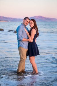 Engaged couple at the beach with an amazing purple sky sunset.