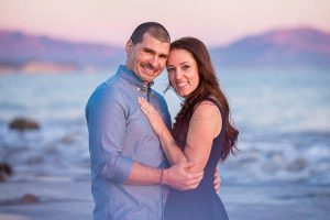 Engaged couple at the beach with an amazing purple sky sunset.
