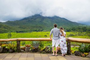 Engaged couple overlooking Arenal Volcano in La Fortuna, Costa Rica, during their La Fortuna engagment photoshoot.