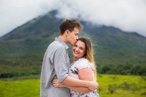 Engaged couple hugging by Arenal Volcano in La Fortuna, Costa Rica, during their La Fortuna engagment photoshoot.