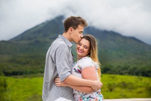 Engaged couple hugging by Arenal Volcano in La Fortuna, Costa Rica, during their La Fortuna engagment photoshoot.