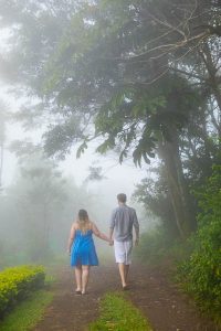 Engaged couple taking photos at their engagement photo session in Monteverde, Costa Rica, as the clouds roll in.