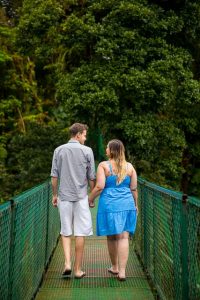 Couple walking across the hanging bridges in the raincloud forest of Selvatura Park in Monteverde, Costa Rica.