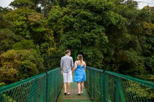 Couple walking across the hanging bridges in the raincloud forest of Selvatura Park in Monteverde, Costa Rica.
