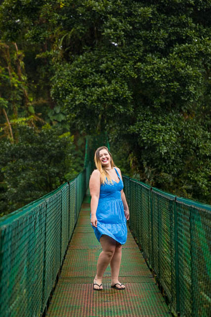 Woman twirling in her dress on a hanging bride in the Costa Rican rain cloud forest.