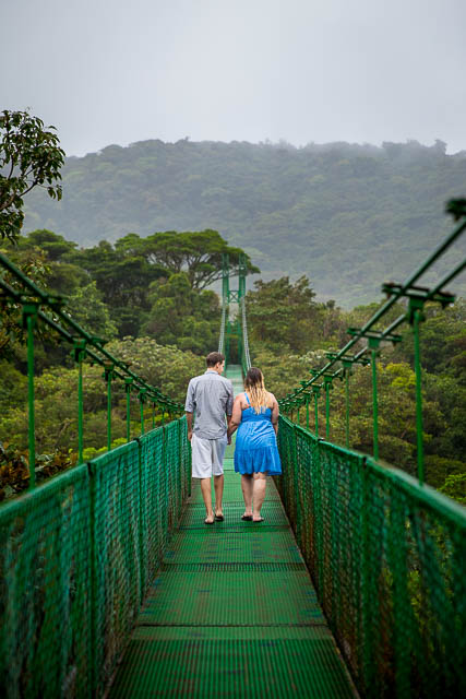 Engaged couple walking across the Selvatura Park Monteverde cloud forest in Costa Rica during their adventurous engagement session.