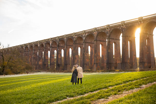 Engaged couple walking together at the Sussex Ouse Valley Viaduct.
