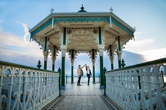 Couple twirling at the Brighton Bandstand on the Brighton Beach seafront. 