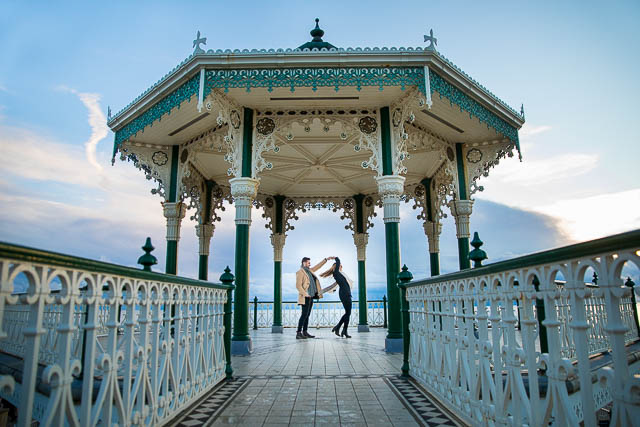 Couple twirling at the Brighton Bandstand on the Brighton Beach seafront. 