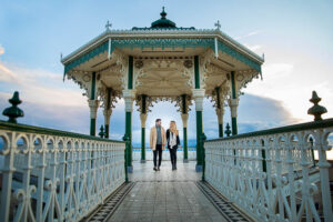 Bride and groom walking together at the Brighton Bandstand.