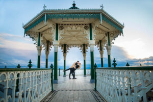Couple twirling at the Brighton Bandstand on the Brighton Beach seafront.