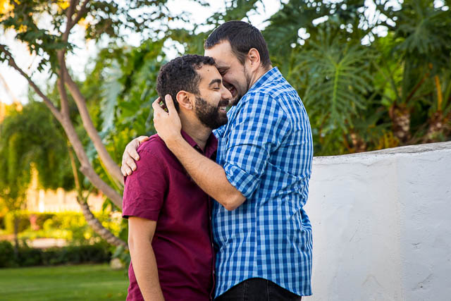 Engaged gay couple laughing with the Santa Barbara Courthouse photographer.