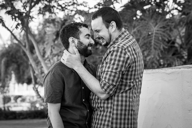 Engaged gay couple laughing with the Santa Barbara Courthouse photographer.